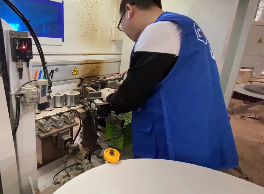 Cabinetry worker operating production equipment in a photograph from the brand catalogue