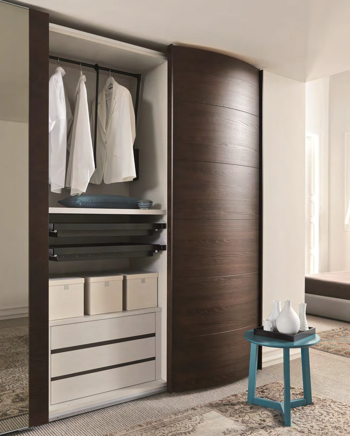 Sliding wardrobe front beside an open hanging section and lower drawers