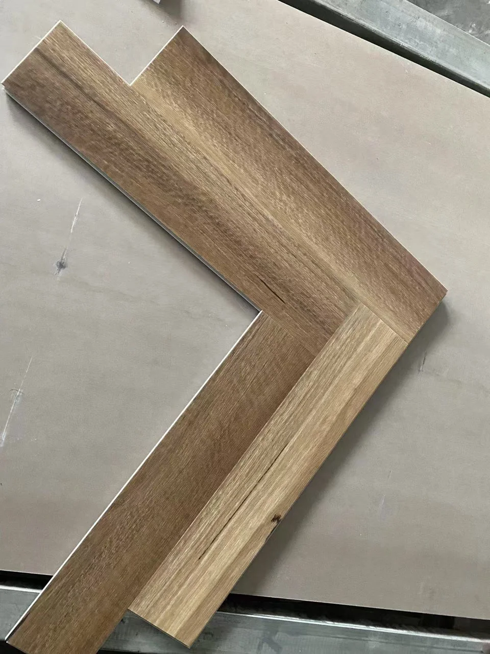Brown SPC herringbone board sample with visible locking edges