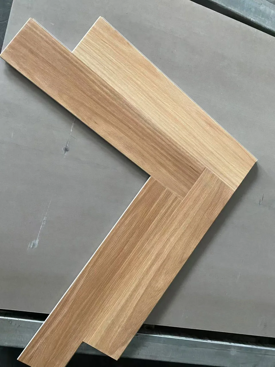 Light SPC herringbone board sample with visible locking edges