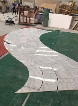 Curved stone stair pieces arranged on a workshop floor