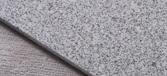 Grey speckled granite slab showing the polished face and straight edge