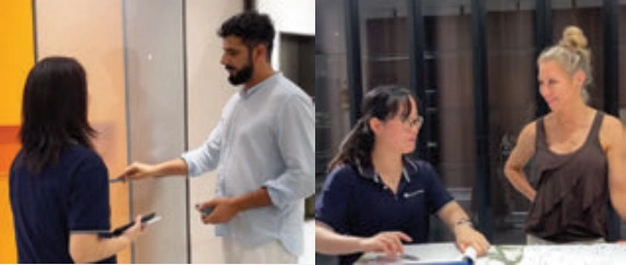 Two showroom discussions: a man pointing to a wall display and two women seated at a table