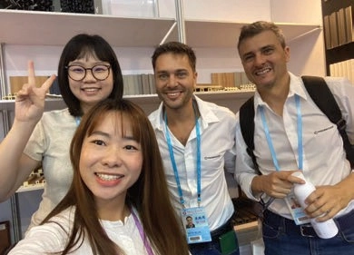 Four people posing for a selfie in a showroom, two wearing visitor badges