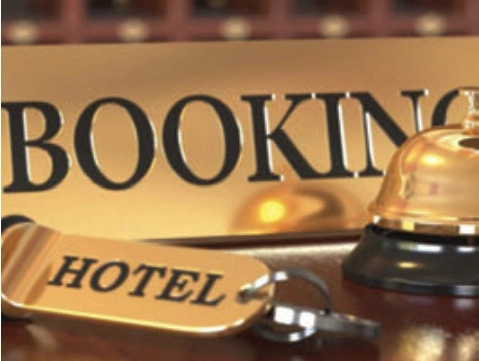 Hotel key tag and reception bell beside a sign reading Booking