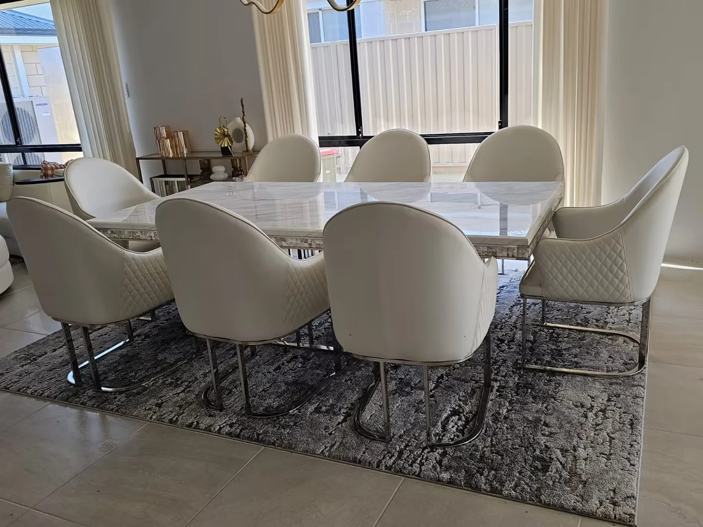 Dining table and upholstered chairs with pendant lighting, curtains and adjoining interior finishes
